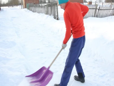 A man clears snow with a shovel. Stock Footage 85001186