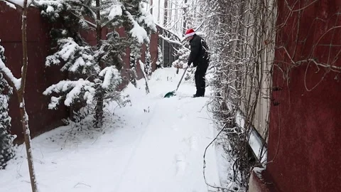 A man clears snow with a shovel Stock Footage 326224991