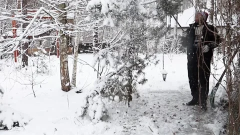 A man clears snow with a shovel Stock Footage 326224997