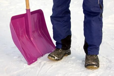 A man clears snow with a shovel.  legs. Stock Photos