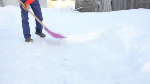 A man clears snow with a shovel. winter. cold weather. Stock Footage 85001250