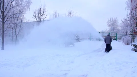 A man clears snow with a snow plow in a park Vídeo Stock 260318094