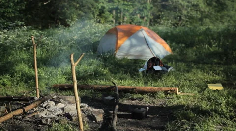 Man clicks on a smart watch and drinking tea. Near the fire is burning and is Stock Footage 64311688