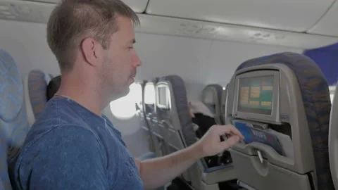 The man clicks on the touch screen in the plane. Video stock 86790369