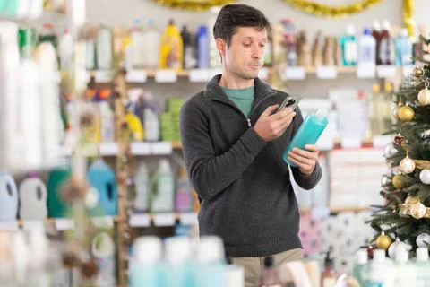 Man client choose and scanning QR code on package shampoo or shower gel Stockfoto's