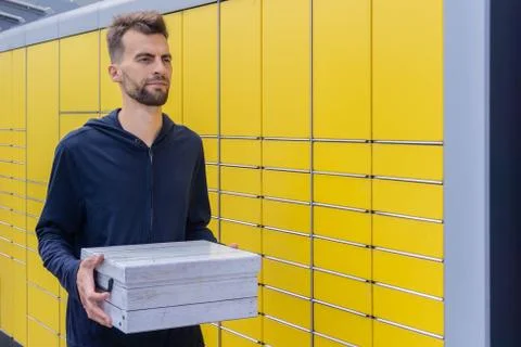 Man client received parcel using automated self-service post terminal machine Foto stock