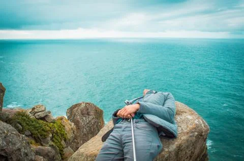 Man on a cliff of ocean Stock Photos