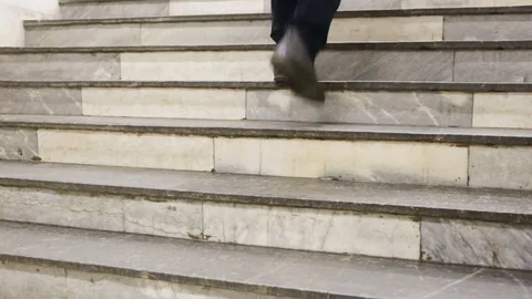 The man climb up the stairs. The guy dressed in slacks and winter boots. Medium Stock Footage 85037382