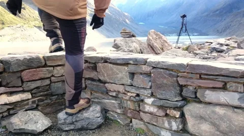 Man Climb Up Stone Wall at at Hooker Lake Glacier Terminal Video stock 64177126