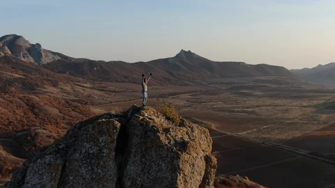 A man climbed to the top of the mountain He dances with happiness and joy Man is Stock Footage 128443782