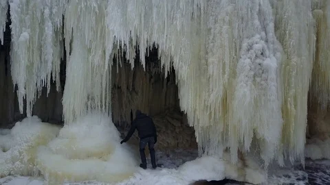 Man climbes into the iced cave Stockbeeldmateriaal 72633942