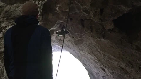 A man is climbing in a cave Stock Footage 266809370