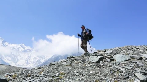 Man climbing down the rocks on mountain slope Stock Footage 77450390