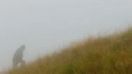 Man Climbing Up Hill, Bad Weather Stock Footage