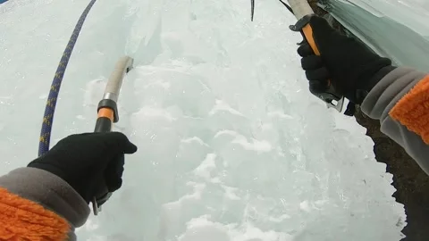 Man climbing ice waterfall with rope and ice axe Stock Footage 170833059