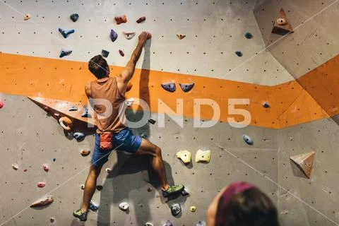 Man climbing indoor boulder wall Stock Photos