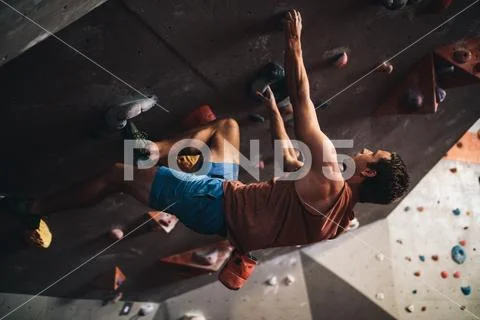 Man climbing indoor boulder wall Stock Photos
