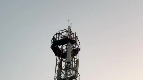 Man Climbing Mobile Tower in Rural Area Highlighting Dangerous Risk Video stock 323104137