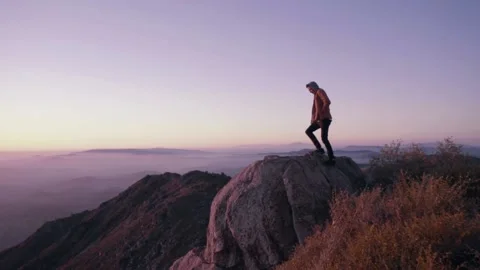 Man climbing mountain during sunset cinematic slowmotion inspirational Stock Footage 151350963