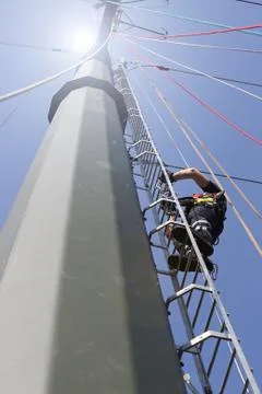 Man climbing pylon Stock Photos