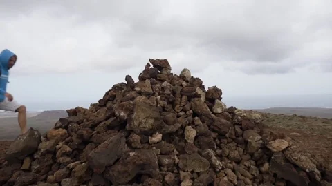 Man climbing the rocks on volcanic landscape Stock Footage 71551287