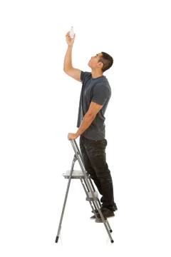 Man climbing stepladder to replace light bulb Stock Photos