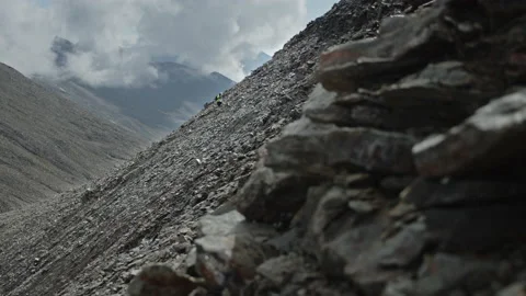 Man climbing under the clouds on a rocky pass in a big mountains Stock Footage 203824121
