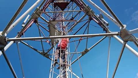 Man climbing vertical cage ladder inside 75m repurposed radar tower Video stock 338115429