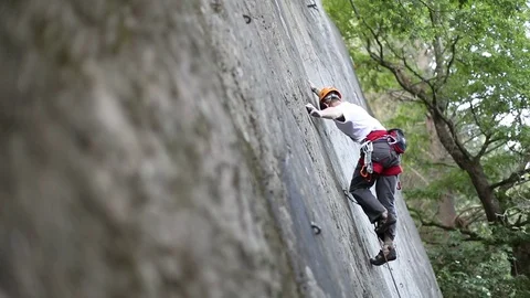 Man climbing vertical rock wall. Person goes aout of focus. Slow motion 120 库存影片 73113050
