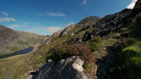 A man climbing a Welsh mountain next to a waterfall and stream Vidéo 163027162