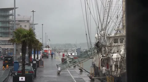 Man climbs aboard old sailing ship in the rain HD Stock Footage 7139202