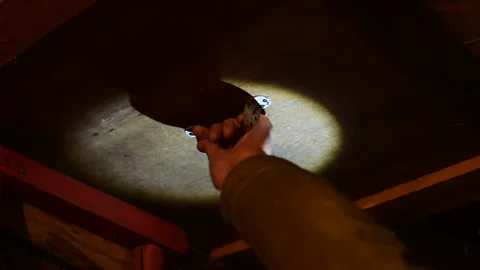Man climbs into the attic in the light of a pocket flashlight Stock Footage 138439069