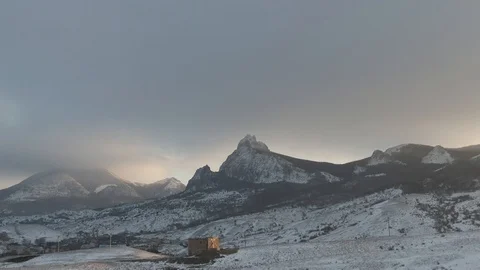 Man climbs a hill in the winter in the rays of sunset Stock Footage 105682461