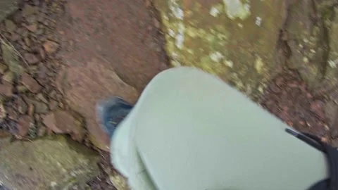 Man climbs up the mountain on a dirt road with stones Stock Footage 171795853