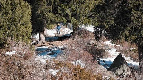 A man climbs the mountain while hiking in the winter on a sunny day Stock Footage 144094529