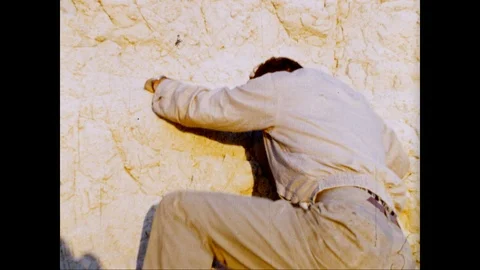 Man climbs a rock face in Death Valley, 1950's archival film Stock Footage 125836783