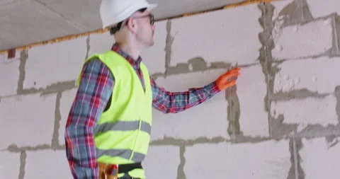 Man climbs up stepladder and checks quality of applied material Stock Footage 309928141
