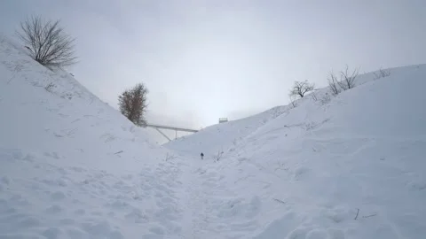 A man climbs through the snow, a man's path through the snow Stock Footage 238003184