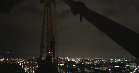 Man Climbs to the Top of a Crane at Night Stock Footage 87722559