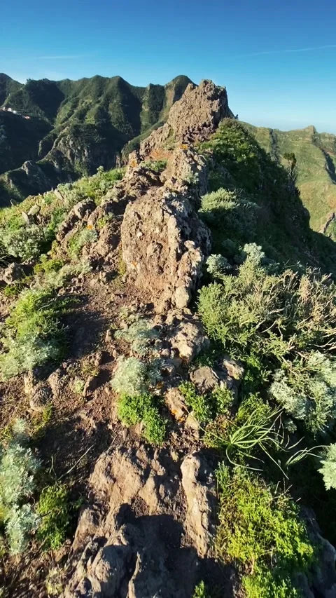 Man climbs to top of mountain and walks along stone path. The sun is shining and Stock Footage 156803554