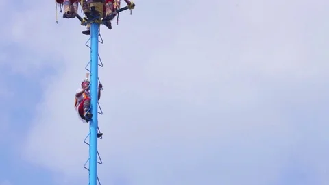 A man climbs a tower in the traditional dance of "Los voladores de Papantla" Stock Footage 77371860