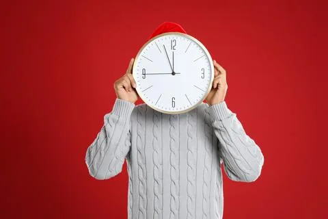 Man with clock on red background. New Year countdown 스톡 사진