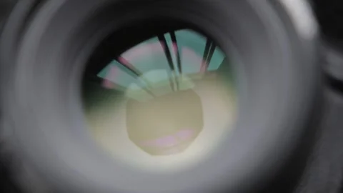 A man close down the aperture/diaphragm from modern camera lens limiting the lig Stock Footage 169975837