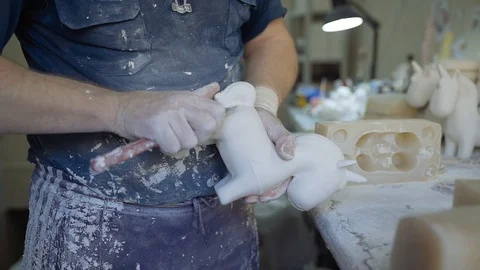 A man close-up makes a children's toy from plaster Stock Footage 102258406