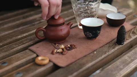 The man closed the lid of the clay teapot and took the teapot in his hand Stock Footage 229860875