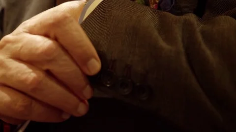 A man closes the buttons of his jacket cuff. Detail. About crafts, tailoring Stock Footage 83593549