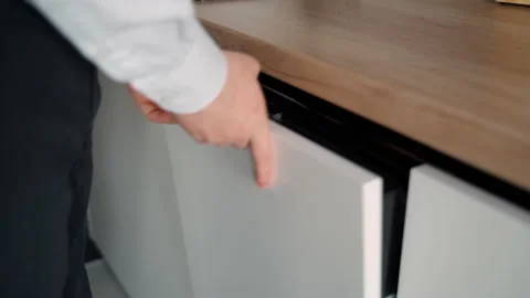 A man closes a dishwasher with a white facade Stock Footage 153280997