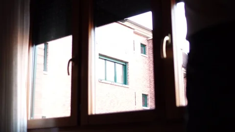 The man closes the exterior heavy blinds on the plastic brown window of the r Stock Footage 118090102