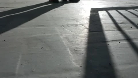 Man closes the gate, shadow on the concrete floor. Stock Footage 136022623