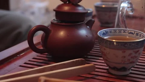 Man closes the lid of teapot filled with freshly brewed tea, emphasizing the Stock Footage 278042879